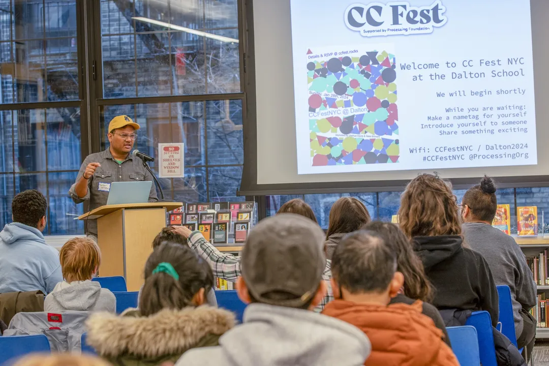 A presentation at CC Fest, with the audience facing a bright projection.