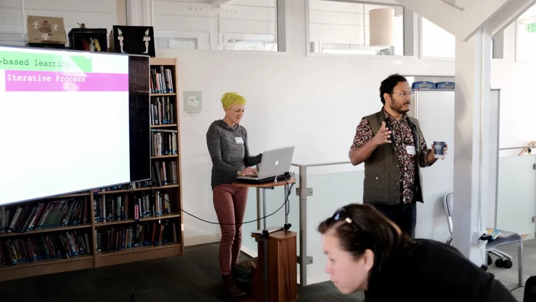 Two presenters lead a session in the school library.